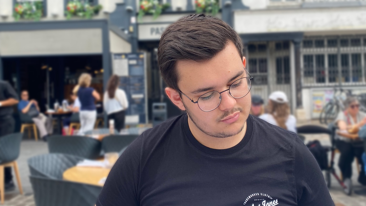 Léo Wadin in a restaurant, looking at the menu.